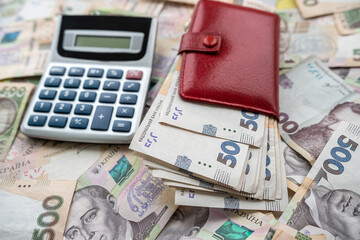 financial concept uah ukraine money with calculator and purse on desk