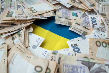 Ukrainian hryvnia lying on national blue yellow flag of Ukraine