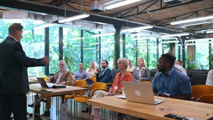 Video of a business conference meeting with an educator speaking to the people in the room. Cinematic footage representation of public speaking concepts and self improvement motivational summits