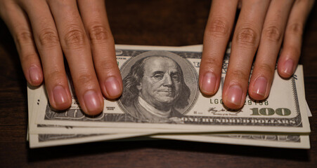 Hand holding money 100 dollars, investment and finance business concept.