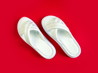 Women's summer white slippers on a red background. Slippers. Horizontal image