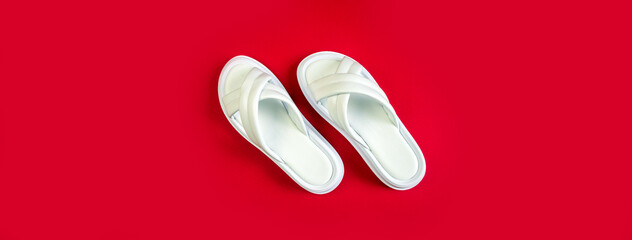 Women's summer white slippers on a red background. Slippers. Banner for insertion into site. Place for text cope space. Horizontal image
