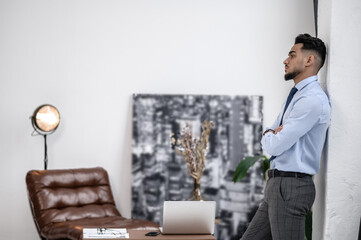 Man standing sideways to camera with hands folded