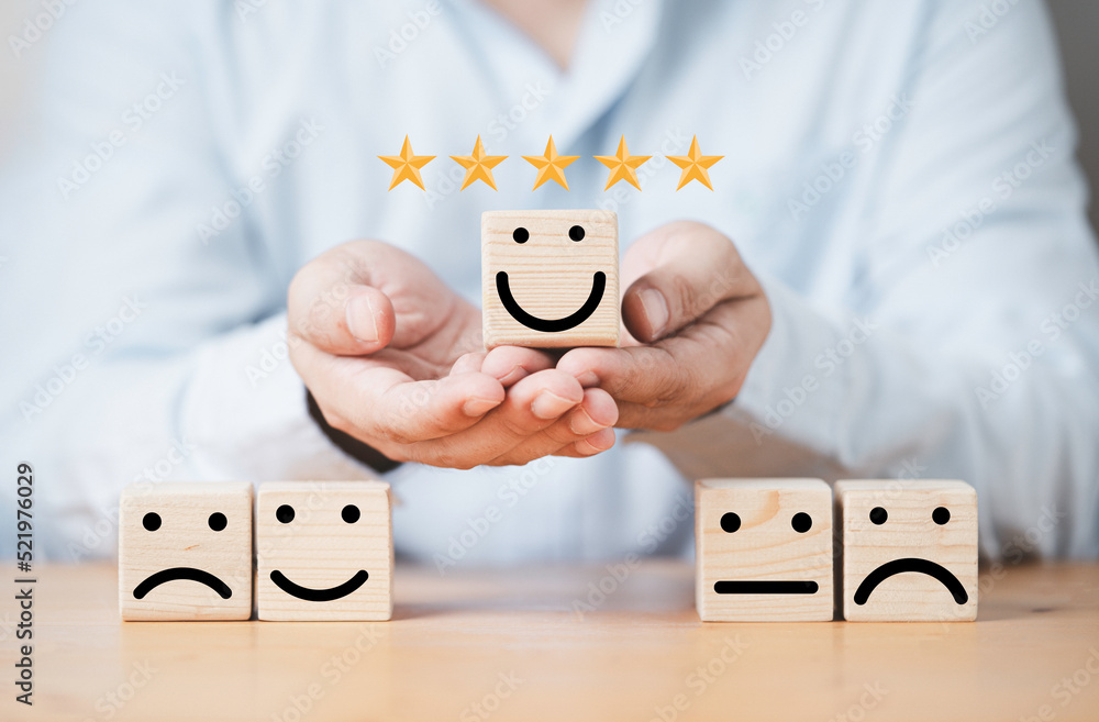 Poster businessman holding smile face on wooden cube block with other face emotion for excellent evaluation