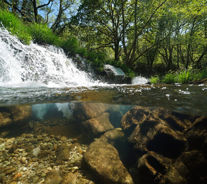 Small waterfall on a river over and under water surface split level view, Spain, Galicia, Rio Verdugo