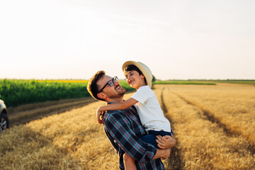 father and son in wheat field. father holding his son