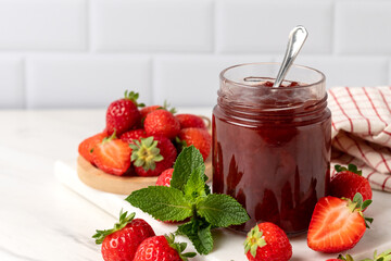 strawberry jam in glass jar and fresh strawberries
