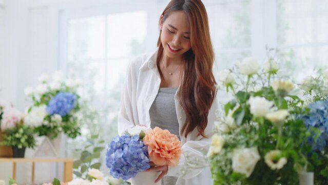 Small business,business online and New market concept.Young florist female use smartphone take photo bouquet of flower send to customer at workplace.woman artist working in flower shop studio at home