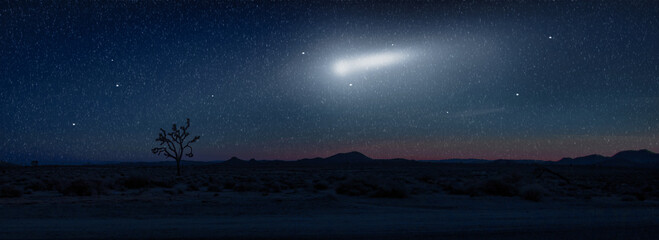 blue night sky over desert with falling stars and moon