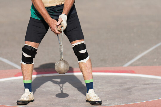 An athlete competing in the hammer throw event, athlete performing a hammer throw in stadium