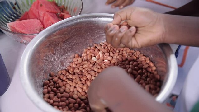 Removing stones or bad peanuts or groundnuts in preparation for frying or roasting them