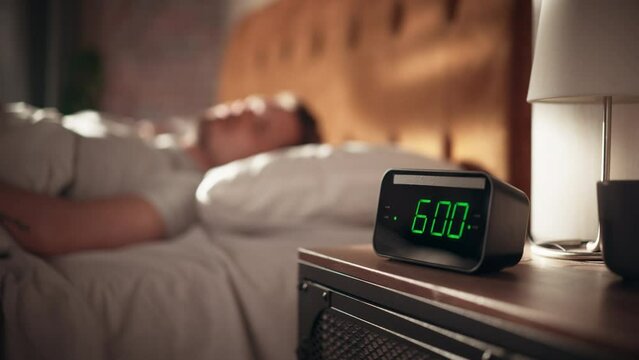 Man Wakes Up and Turns off Alarm Clock. Early Rising Productive Man Ready Start a Day full of New Business Projects, Adventures. Focus on Clock Showing Six O'Clock. Sun is Shining. bedroom Apartment