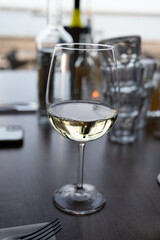 Drinking white dry wine in outdoor cafe with sea view
