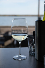Drinking white dry wine in outdoor cafe with sea view