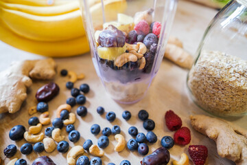 Healthy fruit shake on table with fruits and vegetables ingredients around.