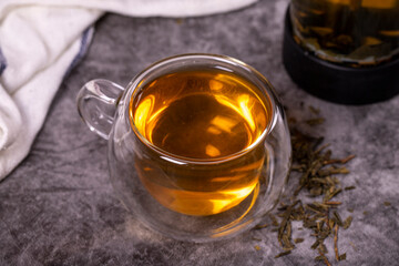 Green tea. Green tea brewed with French press on a dark background. Healthy drinks. Herbal tea concept. close up