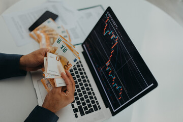 Businessman man counting euro money working on computer at office desk, inflation concept., top...