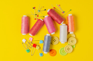 Sewing accessories on a yellow background. Closeup.