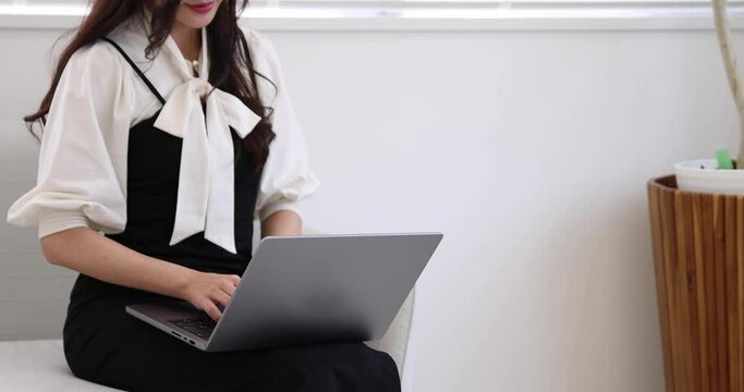 A Japanese woman typing laptop by remote work in the office faceless composition