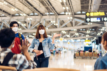 Young couple traveler in quarantine for coronavirus wearing surgical mask face protection waving hi and saying hello with friend after long travel vacation flight at International terminal airport