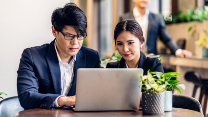 Group of professional asian business discussing meeting strategy sharing idea with new project.Creative business people working and talk in green plant terrace decorated modern workloft