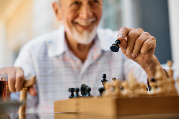 Close up of senior man playing chess at retirement community.