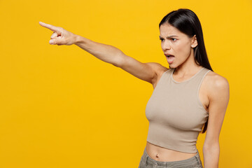 Side view young angry furious sad mad indignant latin woman 30s she wearing basic beige tank shirt...