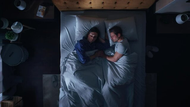 Top View Apartment: Happy Young Couple Sleeping in Bed at Night. Beautiful Girlfriend and Handsome Boyfriend Sleeping Together. Family of two Sweetly Sleeping Facing Each other. Top Down Static Shot