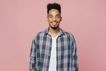 Young smiling happy cheerful fun cool man of African American ethnicity 20s he wearing blue shirt look camera isolated on plain pastel light pink background studio portrait. People lifestyle concept.