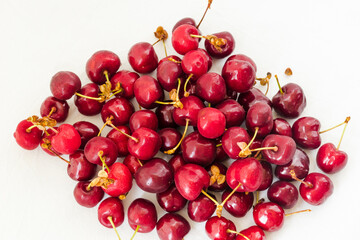 Lots of sweet red cherries closeup. Red cherries isolated on a white background. Juicy organic red cherries berries for jam, juice, smoothie, compote, desserts and cakes.