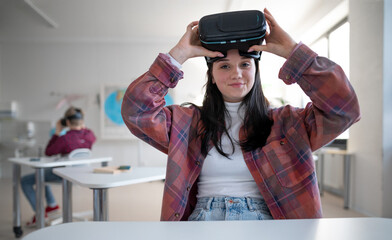 Happy student wearing virtual reality goggles at school in computer science class