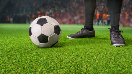 A soccer player with the soccer ball at the big stadium ready to kick off.