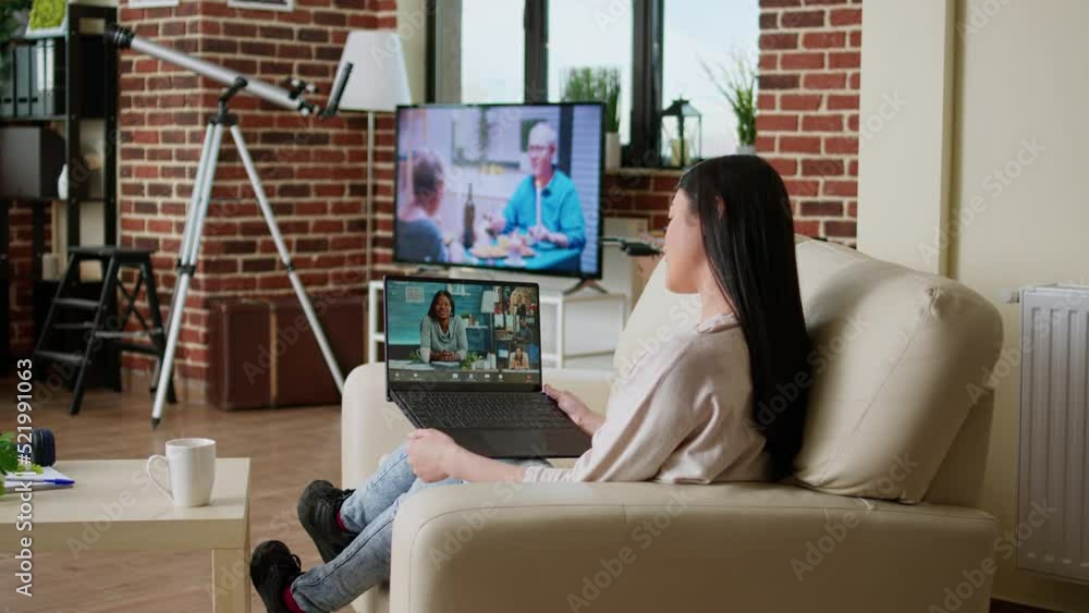 Poster woman sitting on couch working remotely while discussing with office manager on video call conferenc