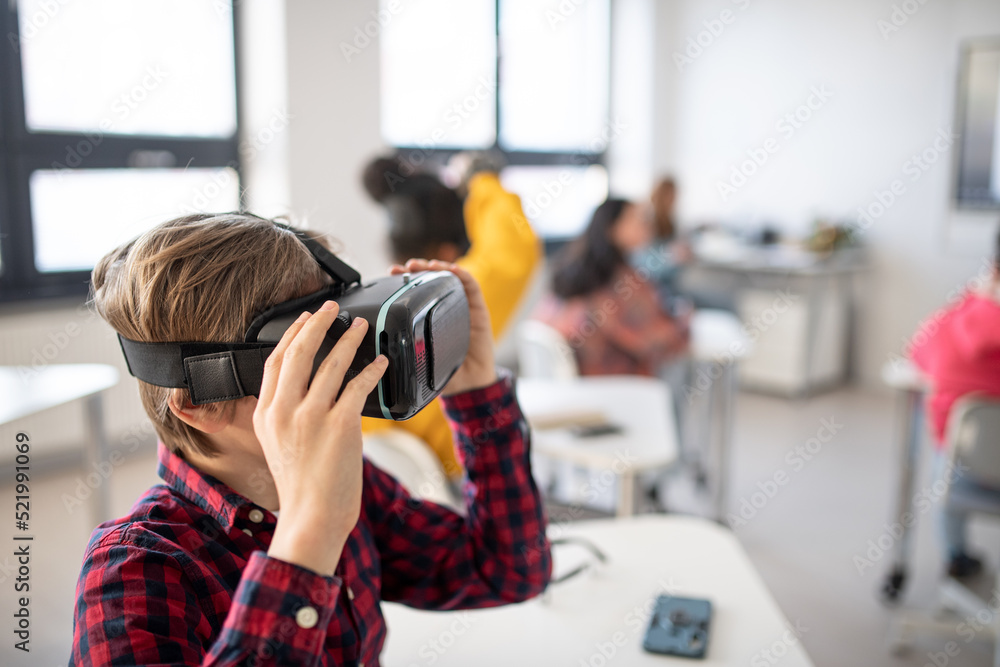 Wall mural curious student wearing virtual reality goggles at school in computer science class