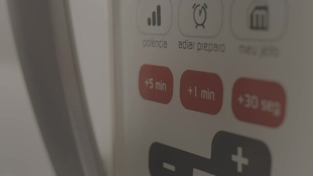 ungraded close on microwave, finger selecting plus one minute, handheld camera, slow motion in alexa mini