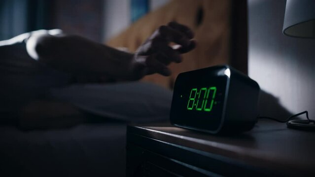 Man Wakes Up and Turns off Alarm Clock. Early Rising Productive Man Ready Start a Day of New Business Opportunities. Focus on the Clock Showing Eight O'Clock on Bedside Nightstand bedroom Apartment