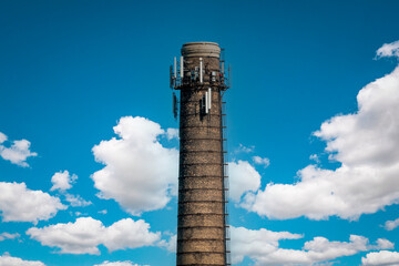 Chimney of a thermal power plant of a boiler room heating against a  sky background