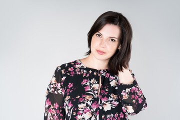 Plus size model in casual clothes, fat woman on gray background, overweight female body