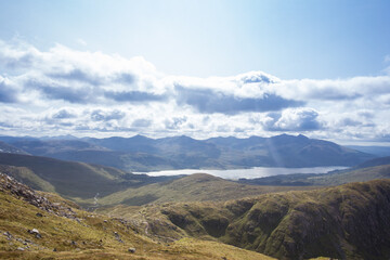 clouds over the mountains and a lake with sun rays coming down