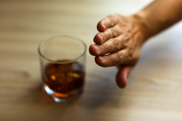 Hands lock chain a glass of whiskey To stop drinking.