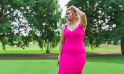 Plus size American blonde woman in pink midi dress at nature. Life of people xl size, happy nice natural beauty woman