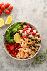 Fresh sea food salad with green mix, cherry tomatoes, herbs and olive oil, lemon dressing. Healthy food