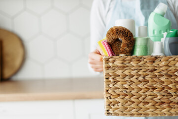 Woman hands holding wicker basket with detergents