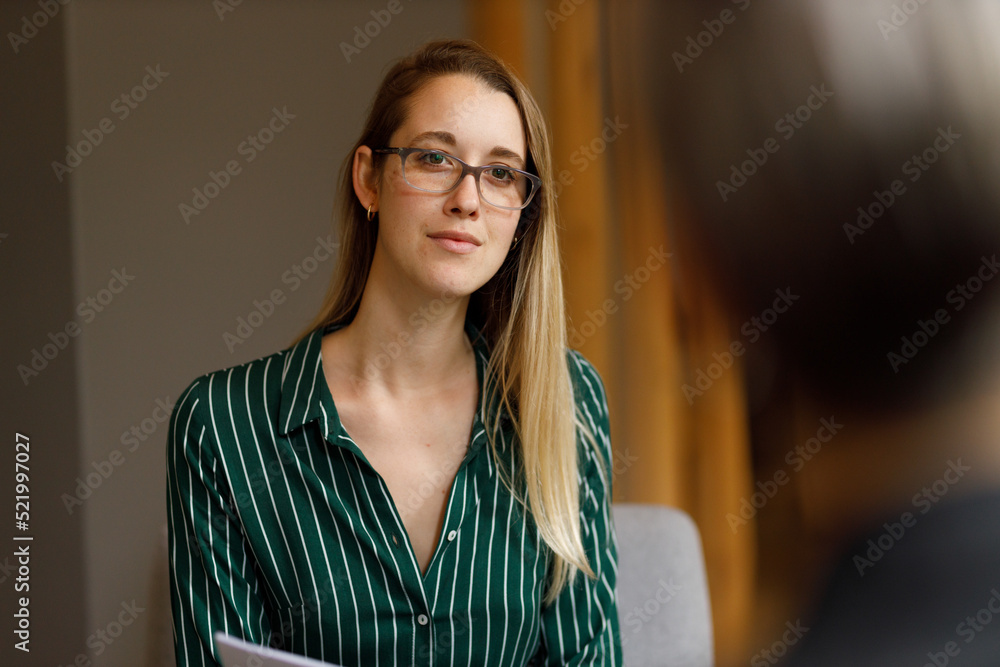 Wall mural Focused female associate listening in meeting at office