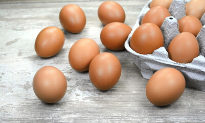 Brown eggs in craft carton pack on hay at rustic wood table with copy space. Fresh chicken eggs background.  Natural healthy food and organic farming concept.