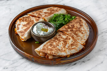 Pita with meat and vegetables in a  plate on a marble background. Restaurant banquet menu.