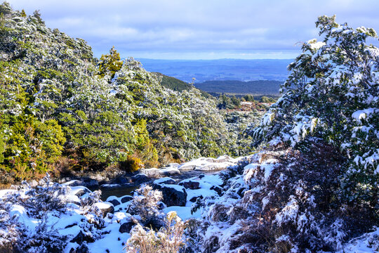 Looking down over Tongariro National Park from the side of Mangawhero River, riverbed covered with snow. Mountain Ruapehu, North Island, New Zealand