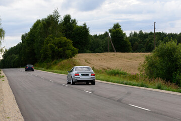 beautiful car on an asphalt highway on a cloudy day in summer