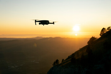 Naklejka na ściany i meble Drone in Flight at Sunset Over a Valley