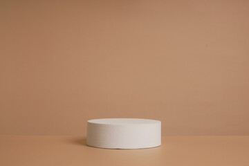 Abstract empty white podium with geometric shadows and pink flowers on blue background. Mock up stand for product presentation.Minimal concept. Advertising template